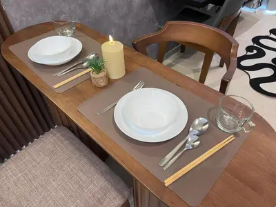 a table with two white plates and a candle on it at NEW Georgetown 22 Macalisterz Elegant 2BR 5pax in George Town