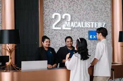 a group of people standing around a reception desk at 22 Macalisterz Leisure Suites George Town in George Town