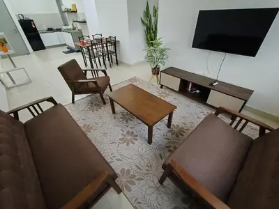 a living room with a tv and a table and chairs at Aplan Falim by Irainbow in Ipoh