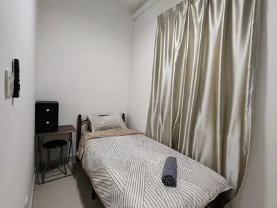 a small bedroom with a bed and a window at Aplan Falim by Irainbow in Ipoh