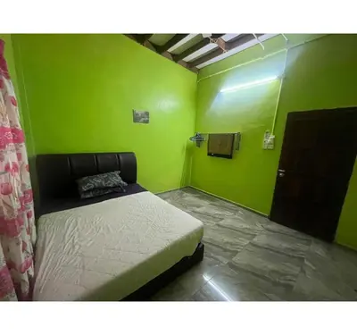a bedroom with green walls and a bed in it at Capital O 91206 Homestay Pelangi Ban Pecah. (muslim Only)