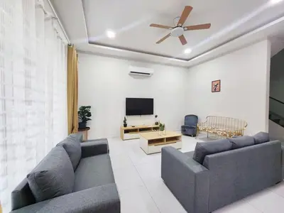 a living room with a couch and a ceiling fan at Ipoh Seri Botani 5br22 pax bbq mahjong in Kampong Kepayang