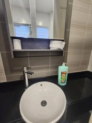 a bathroom with a white sink and a mirror at Ipoh Seri Botani 5br22 pax bbq mahjong in Kampong Kepayang