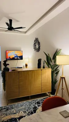 a living room with a wooden cabinet and a ceiling fan at 122 SEGARi in Lumut