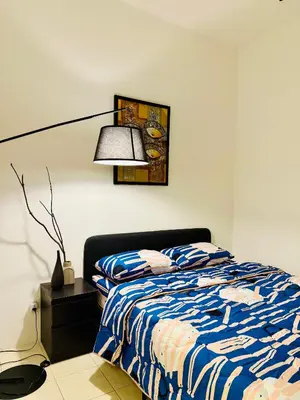 a bedroom with a bed with a blue and white comforter at 122 SEGARi in Lumut