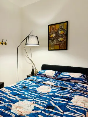 a bedroom with a bed with a blue comforter at 122 SEGARi in Lumut