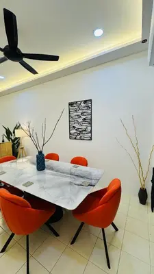 a dining room with a table and orange chairs at 122 SEGARi in Lumut
