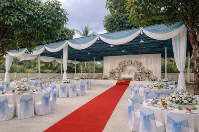 a banquet hall with white tables and blue chairs at MY LENA Villa in Baling
