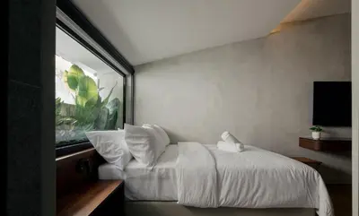 a bedroom with a white bed and a window at Bishop House in George Town