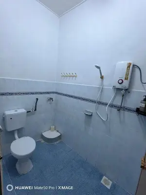 a bathroom with a toilet and a phone on the wall at TL Legend Homestay2 - 4 bedroom single story house in Ipoh