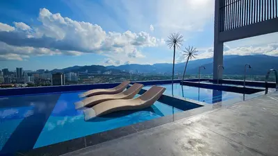 a swimming pool with lounge chairs on a building at Cozy studio with Komtar view at 22 Macalisterz in George Town