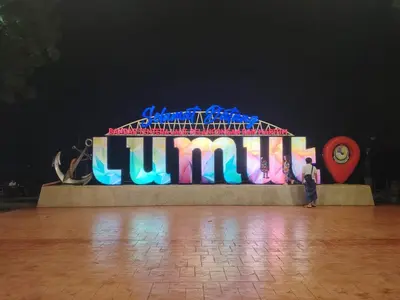 a man standing in front of a lit up sign at Ed 03 lumut Waterfront in Lumut