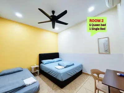 a room with two beds and a ceiling fan at MiuMiu Homestay in Teluk Intan