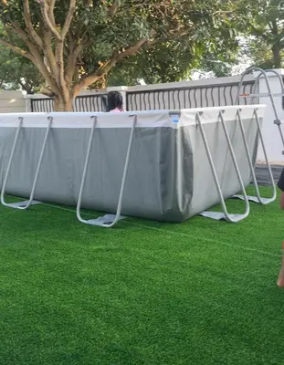 a table on the grass with a person sitting on a bench at Madam Cottage Homestay in Sungai Petani
