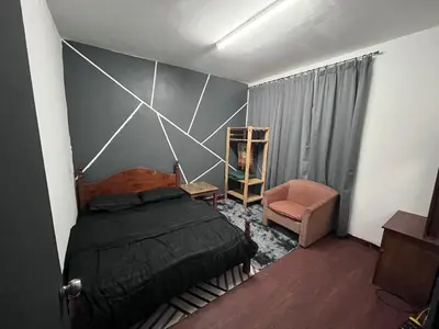 a bedroom with a bed and a chair at Dheaa's Homestay Cameron Highlands in Tanah Rata