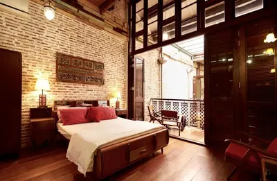 a bedroom with a large bed and a balcony at You Le Yuen in George Town