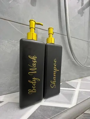 two black and yellow bottles sitting on a bathroom floor at Intan Pearl Homestay in Teluk Intan