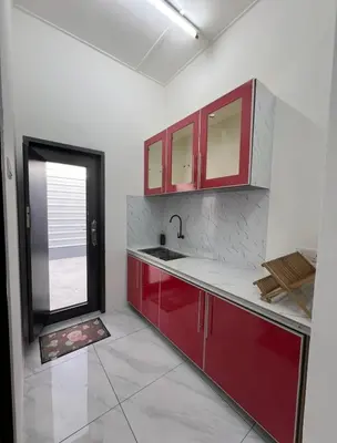an empty kitchen with red cabinets and a window at Intan Pearl Homestay in Teluk Intan