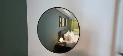 a mirror on a wall with a bed and a lamp at Maritime Suite with Seaview 2BR - Water Dispenser - Dryer in George Town
