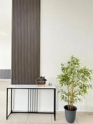 a table with a potted plant next to a wall at Sekinchan 2008 Homestay KaraokeBBQ 20pax \u4e09\u5c42\u7b80\u7ea6\u98ce\u540d\u5bbf in Sekincan