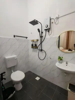 a bathroom with a toilet and a sink and a mirror at Seri Indah Homestay Bandar Baru Kuala Lipis in Kuala Lipis