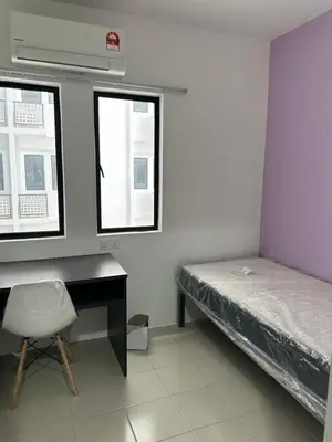 a bedroom with a bed and a desk and windows at The Cozy Loft in Kampar