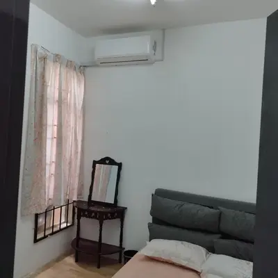 a bedroom with a bed and a couch and a mirror at Mastermind Kemboja Homestay in Sungai Petani