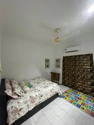 a bedroom with a bed and a brick wall at GerchangLakeHouse in Behrang Hulu