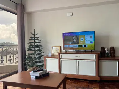 a living room with a tv and a christmas tree at Moriash Stay in Brinchang