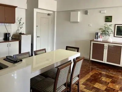 a kitchen with a white counter top and chairs at Moriash Stay in Brinchang