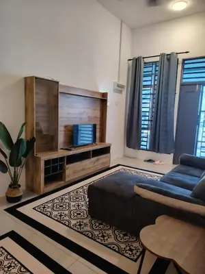 a living room with a couch and a tv at FH Homestay Kuala Lipis 3R2B in Kuala Lipis