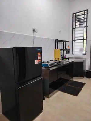 a kitchen with a black refrigerator and a counter at FH Homestay Kuala Lipis 3R2B in Kuala Lipis