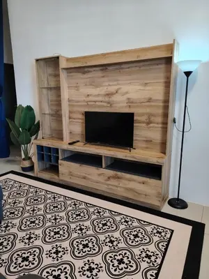 a living room with a tv on a wooden wall at FH Homestay Kuala Lipis 3R2B in Kuala Lipis