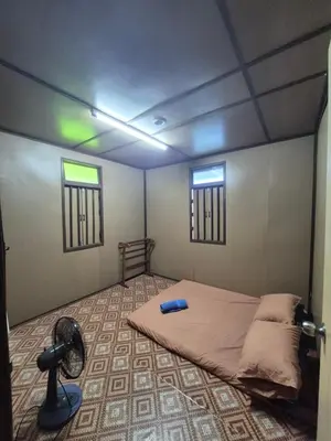 a room with a bed and a fan in it at Homestay Sayang Salmah in Balik Pulau