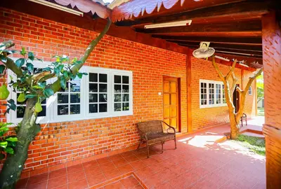a brick house with a chair on a patio at DAWA Brickhouse - Balinese Guesthouse in Thompson Ipoh by Ryokan Management in Ipoh