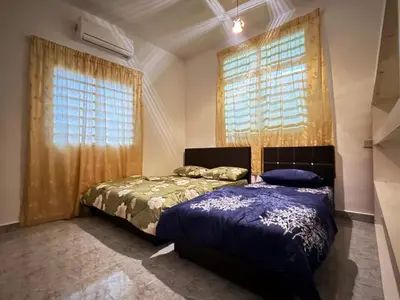 a bedroom with two beds and two windows at Cozy 4BR Homestay with 2 Baths Taman Seraya in Kulim