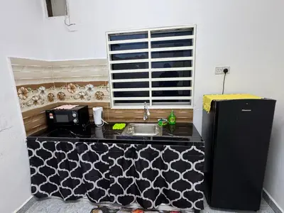 a small kitchen with a sink and a refrigerator at Cozy 4BR Homestay with 2 Baths Taman Seraya in Kulim