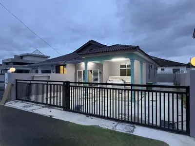 a house with a black fence in front of it at Cozy 4BR Homestay with 2 Baths Taman Seraya in Kulim