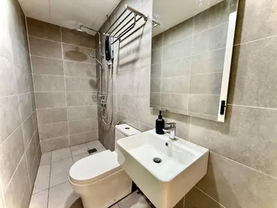 a bathroom with a white toilet and a sink at ICC Luxury Suites by Grab A Stay in Ipoh