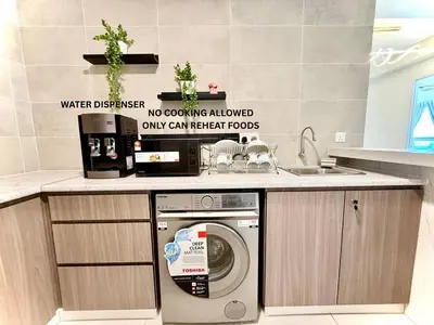a kitchen with a washing machine under a counter at ICC Luxury Suites by Grab A Stay in Ipoh