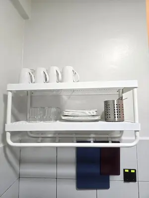 a white shelf in a kitchen with plates and utensils at The Highland Hive in Tanah Rata
