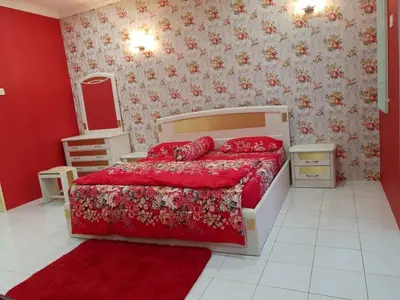 a bedroom with a bed and a red wall at SRS WIN Homestay BPJ in Sungai Petani