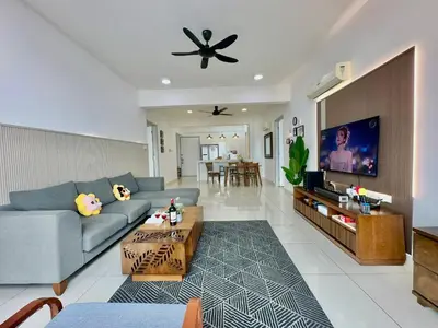 a living room with a couch and a tv at New Reno Jazz Suite 2 bedroomsSeaviewKaraoke in Tanjong Tokong
