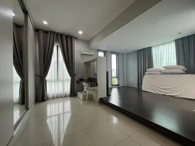 a bedroom with a bed and a desk and windows at Asimmy Homestay Semi-D with 4 rooms in Kampong Gurun