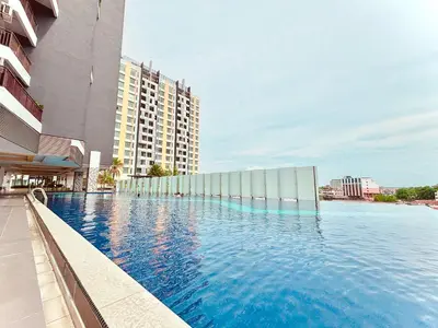 a large swimming pool next to a tall building at Majestic Condo Ipoh Central by PLY Home in Ipoh