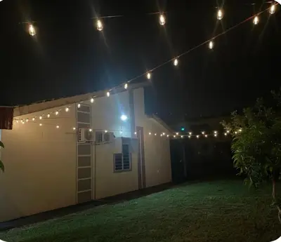 a group of lights hanging over a garage at night at Aileen Homestay Swimming Pool in Batu Gajah