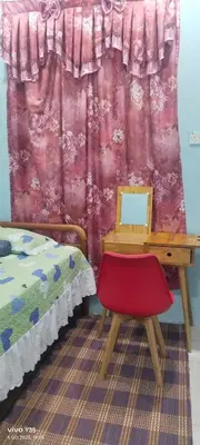 a desk and a chair in a room with a bed at Ulie Empire Homestay in Sungai Petani