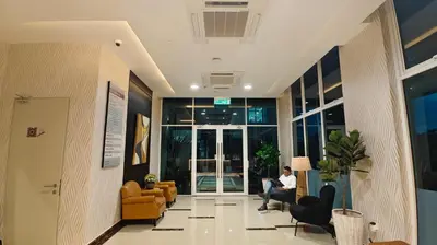 a person sitting in a lobby with a laptop at Hotel Warisan in Taiping