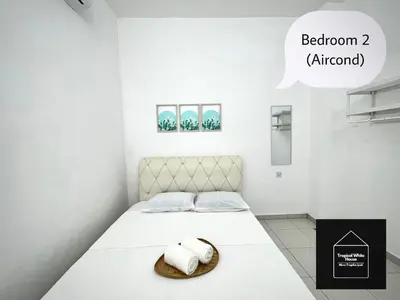 a bedroom with a bed with two towels on it at Homestay Meru Ipoh Mus Lim Only Tropical White House in Ipoh