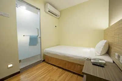 a small room with a bed and a walk in shower at U Design Hotel Bukit Mertajam in Bukit Mertajam